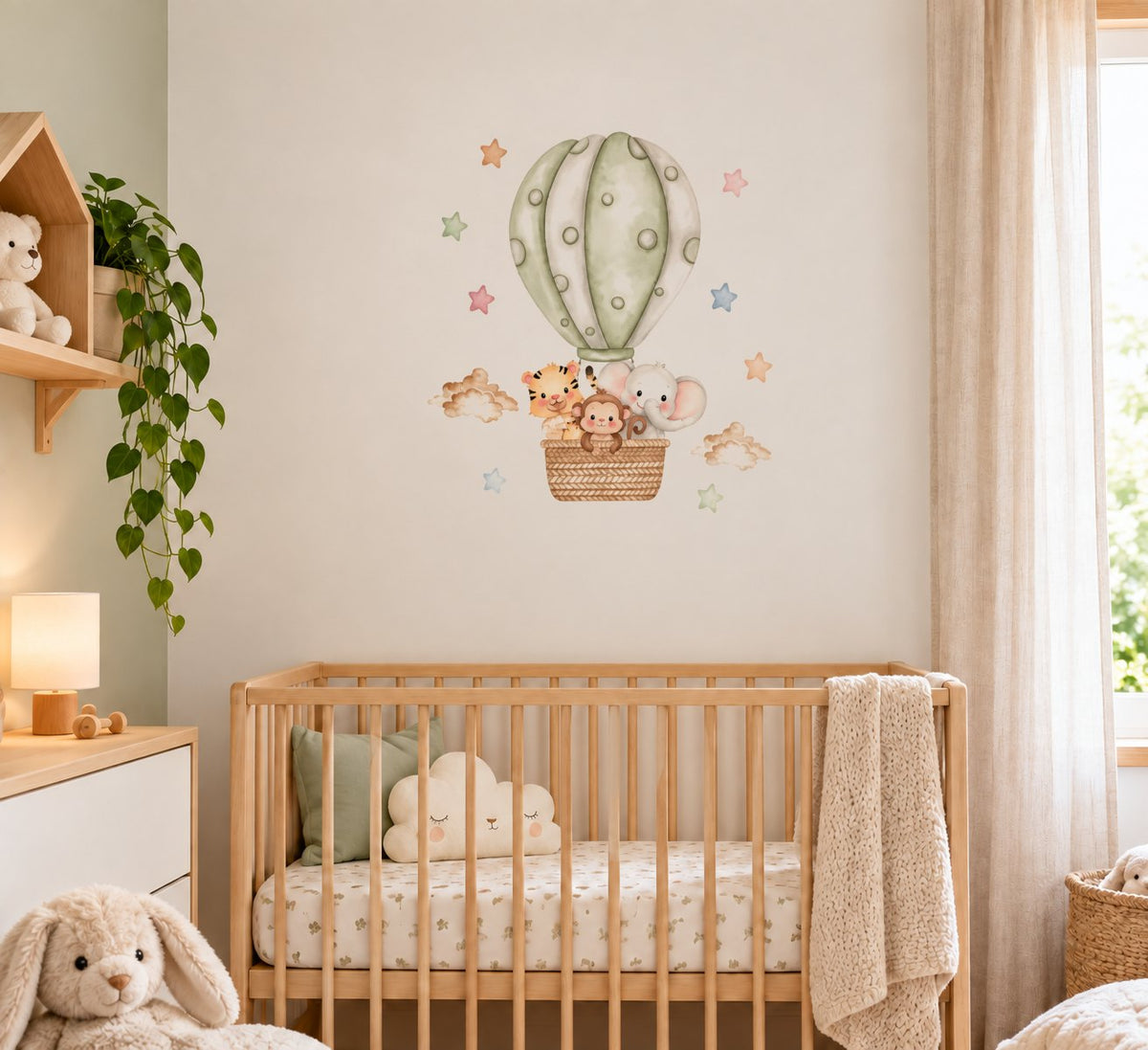 Montgolfière vert sauge posée au-dessus d'un lit bébé, à l'échelle